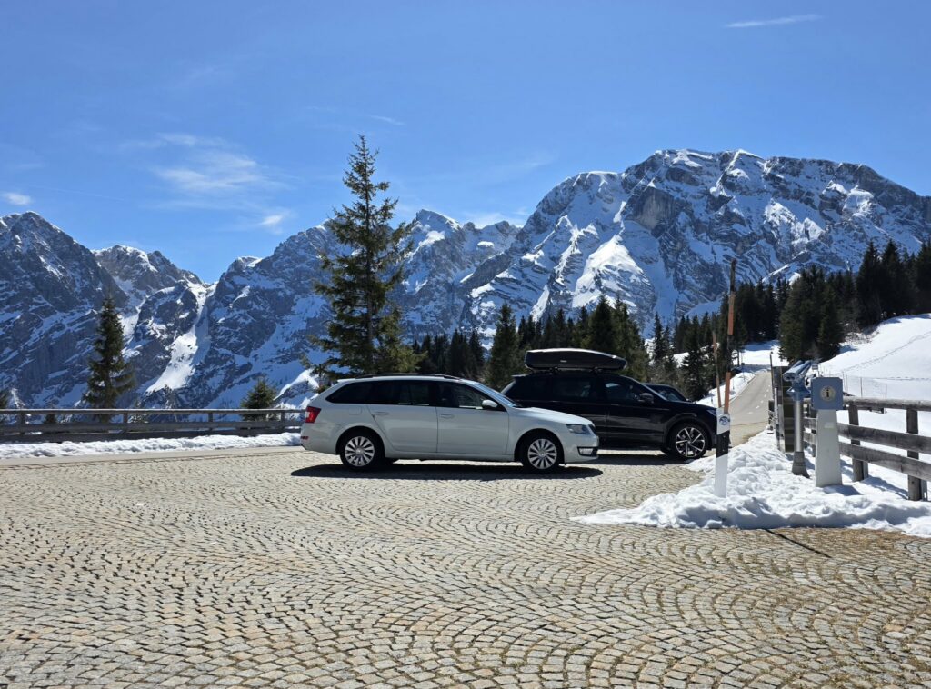 "Panorama-Rossfeldstraße mit Bergblick und meinem Auto vor verschneiter Alpenkulisse."
